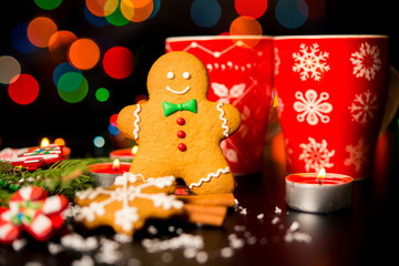Christmas card - gingerbread man gingerbread, christmas decor, snow, candles, cup with cocoa, tea or coffee and Christmas light