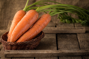 Fresh Organic Carrots in a basket on wooden background