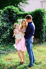 Obraz premium Mom, dad and little daughter walk in the Park. Happy family.