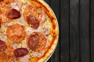 Top view of tasty pizza pepperoni on dark wooden background