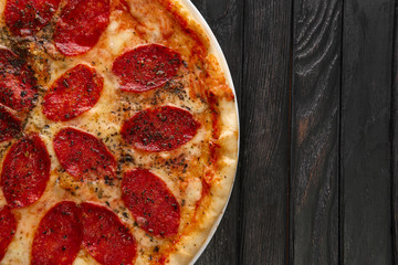 Top view of tasty pizza pepperoni on dark wooden background