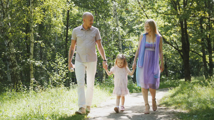 Fototapeta premium Happy family walking in the park at sunny day