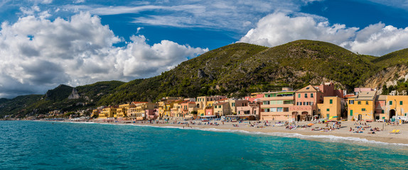 Obraz premium Panoramic view of Varigotti, small sea village near Savona, with crowded beach during a sunny afternoon