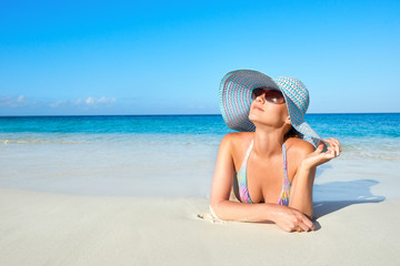 Fototapeta na wymiar woman in bikini and summer hat enjoying on tropical beach