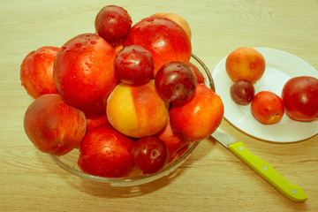 Nectarine, peaches and plums with water drops on wood table. fru
