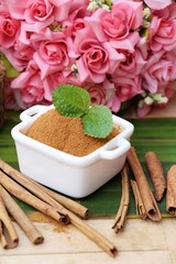 Cinnamon powder and sticks on wood background