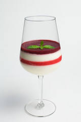 Panna cotta layered with different kind of berries jam, leaves of mint