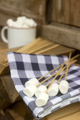 Marshmallow on wooden sticks for frying on an open fire. Rustic style, selective focus.