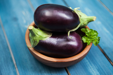 Fresh healthy eggplants on dark wooden background.