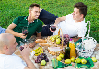Fototapeta premium Three men friends enjoying life on picnic outdoors