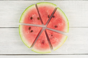 Lot of slices of fresh ripe watermelon on old wooden rustic white table