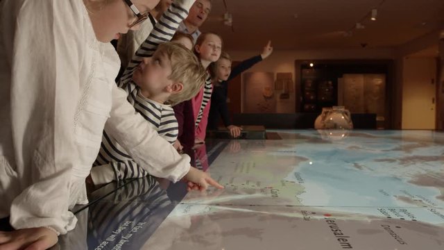 Pupils On School Trip To Museum Looking At Map Shot On R3D
