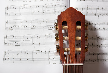 closeup of acoustic guitar on music notes