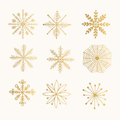 Hand drawn golden snowflakes isolated on background. Ink vector illustration.