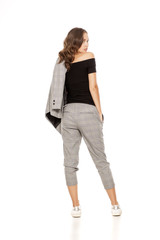 back view of a young beautiful woman in a jacket, blouse and trousers