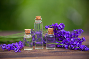 Obraz na płótnie Canvas Essence of lavender flowers on table in beautiful glass jar