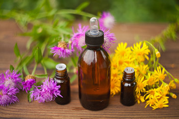 essential oil on table in beautiful bottle with flowers
