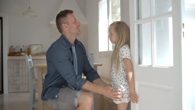 Father Measuring Daughter's Height Against Wall