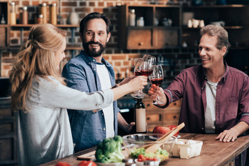 friends drinking wine while cooking dinner