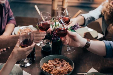 Deurstickers friends drinking wine at dinner © LIGHTFIELD STUDIOS