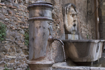 A typical fountain named "nasone" of Rome on the aventino, Italy.