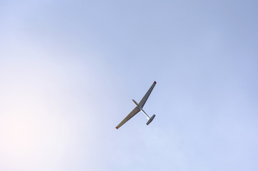 Glider flying on a blue sky background