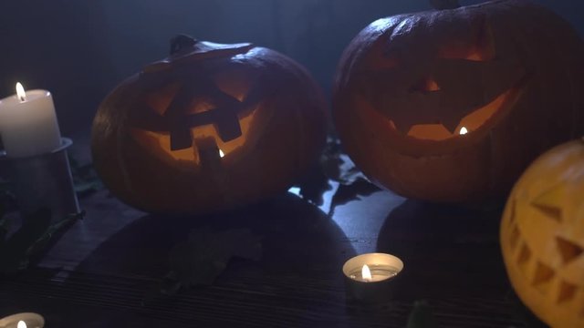 three Halloween pumpkins head jack lantern with burning candles over black background. Halloween holidays art design, celebration. Stock video footage HD 1080p.