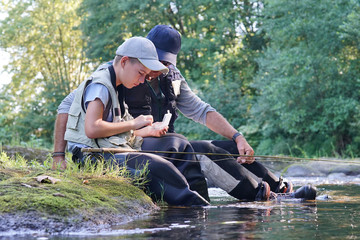 Dad helping son to choose flies for fishing line