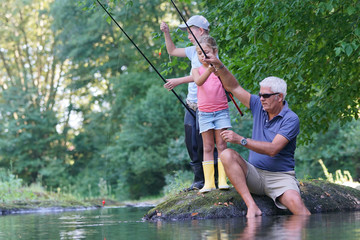 Dad teaching kids how to fish in river