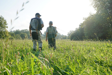 Fototapeta na wymiar Daddy and son walking in field, fishing day