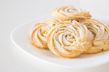 Round shortbread cookies roses form White plate. White background. Copy space.