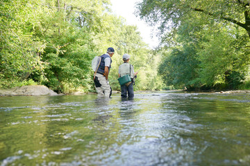 Fototapeta na wymiar Father and son fly-fishing in river
