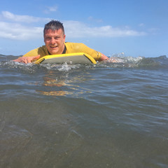Man riding on bodyboard in ocean - 172957721
