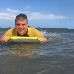 Man riding on bodyboard in ocean - 172957722