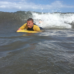 Man riding on bodyboard in ocean - 172957740