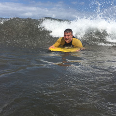 Man riding on bodyboard in ocean - 172957749