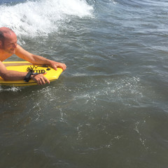 Man riding on bodyboard in ocean - 172957761
