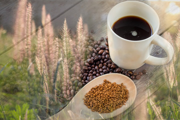 Cup and coffee beans on grass field background