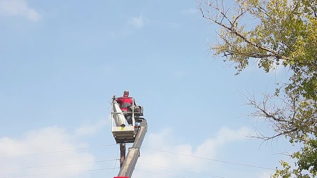 Electric technical repairing street light by boom lift in industrial