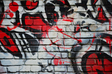 Some elements of a large and composite graffiti pattern on the wall, made with different colors of aerosol paints