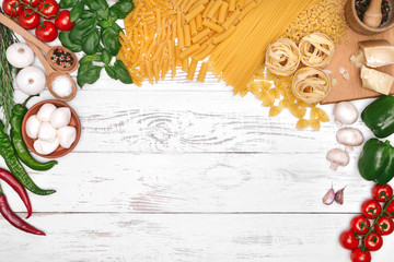 Italian pasta ingredients on white wooden table, top view