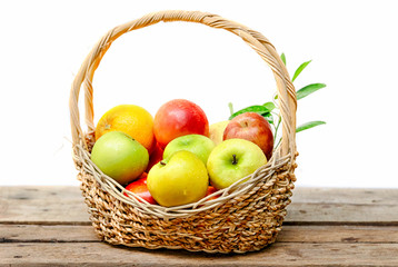 fresh fruits in basket isolated on wooden background