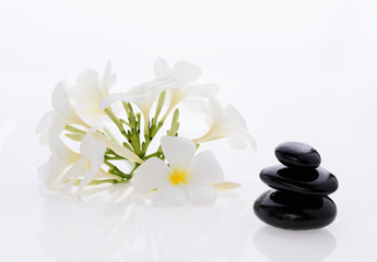 Obraz na płótnie Canvas Pile of zen stones and Frangipani flower isolated on white background