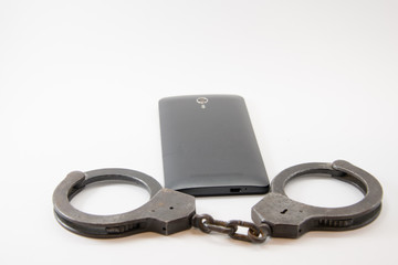 locked phone. phone locked with handcuffs on white background