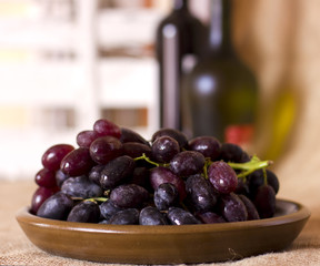 Blue grapes on a clay brown dish