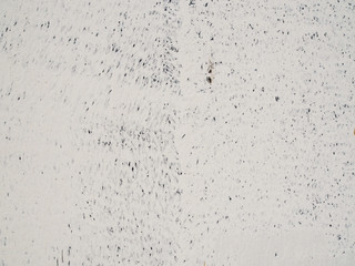 Grungy grainy texture white painted concrete wall background with blue black small ink drop dot stains scattered