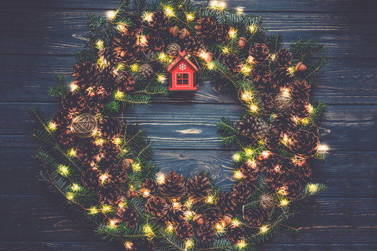 Christmas Wreath With Lights Garland . Homemade Creative Handmade Decor For Home. Holiday Tradition.Dark Toned Photo. Xmas Evening Dinner.