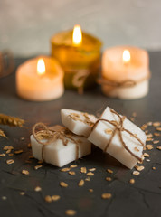 Natural handmade soap, candles oat flakes and wheat ears on wooden background. Spa concept.