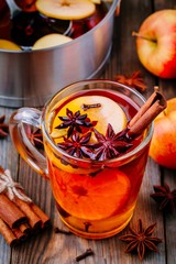 Hot mulled apple cider with with cinnamon sticks, cloves and anise