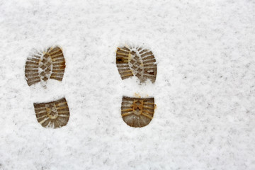 Muddy shoe traces in snow. Seasons concept.